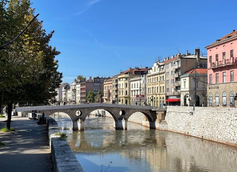 A stone bridge over a river, lined with historic buildings and a museum. 3