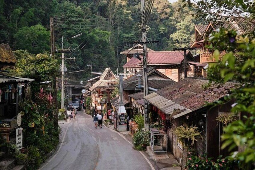 A narrow road in a village with traditional houses and lush greenery. 3