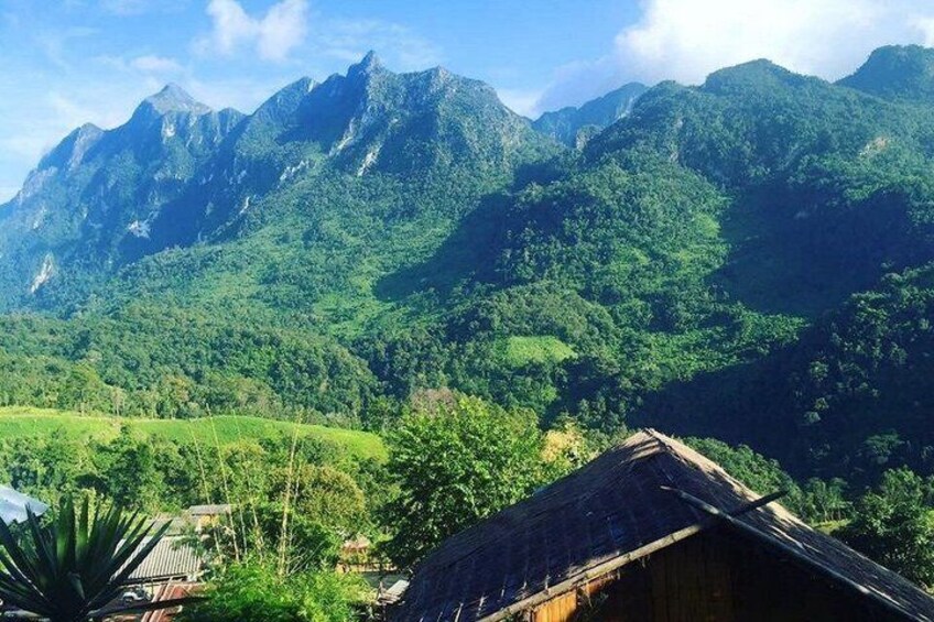 A mountainous landscape with lush greenery and a traditional wooden house. 3