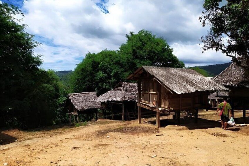 A rural village with thatched-roof huts and a dirt ground. 2