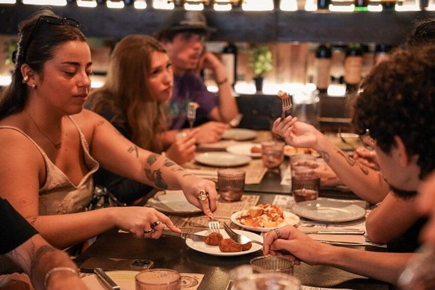 People dining at a restaurant with plates of food and drinks. 2