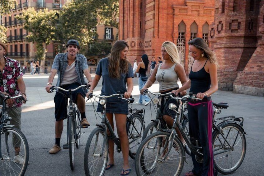 A group of people on bicycles in an urban setting with brick buildings and a clear sky. 5