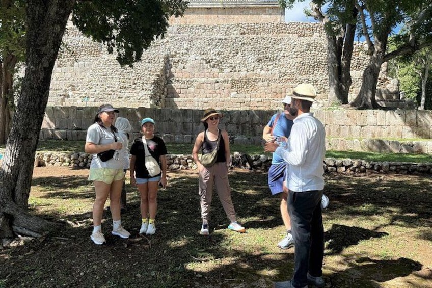 A group of people standing outdoors near ancient stone structures. 4