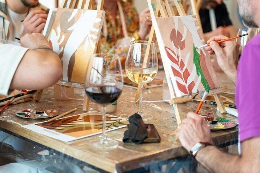 People painting on easels with wine glasses on the table. 3