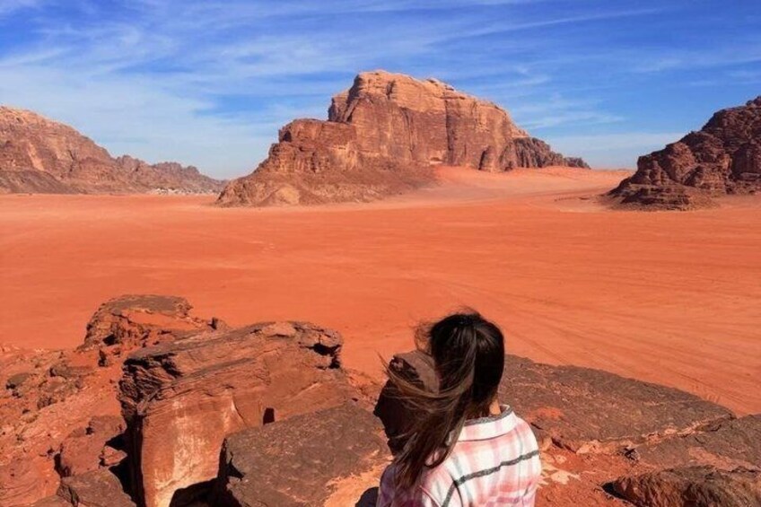 A desert landscape with a prominent rock formation in the distance. 1