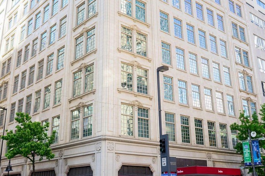 A multi-story building with large windows and a corner entrance. 2