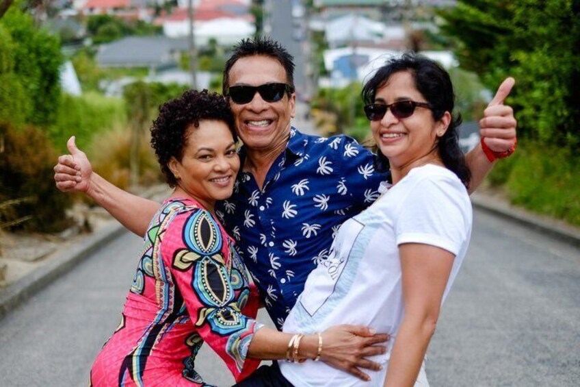 Three people on a paved path with greenery on the sides. 1