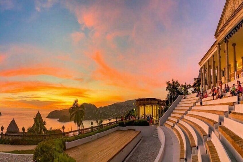 A sunset over a coastal amphitheater with steps and palm trees. 2