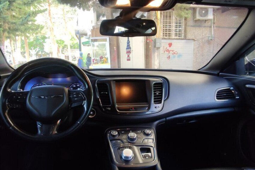 A car's interior with a steering wheel, dashboard, and center console. 2