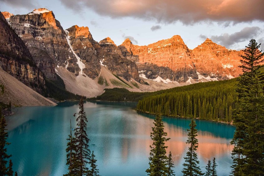 A mountain lake surrounded by forest and rocky peaks. 2