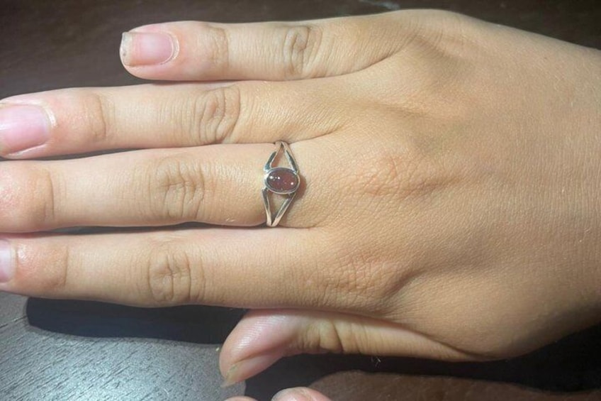 A hand wearing a ring with a gemstone. 2