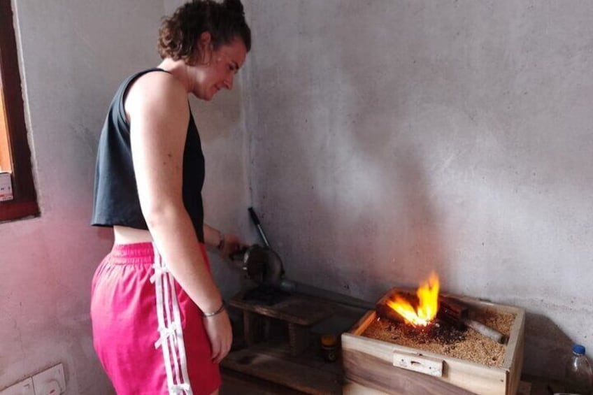 A person tending to a fire in a wooden box. 1