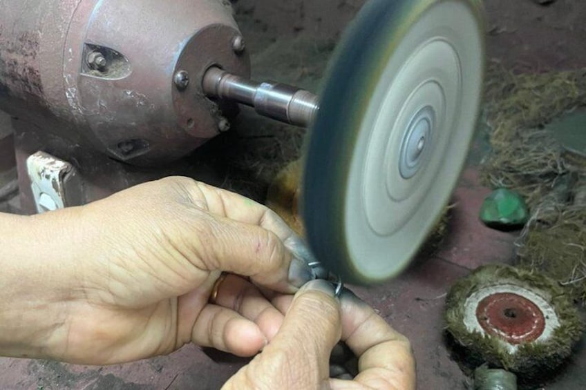 A person using a grinding tool on a metal object. 3