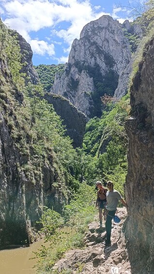 A canyon with hikers on a rocky trail. 4