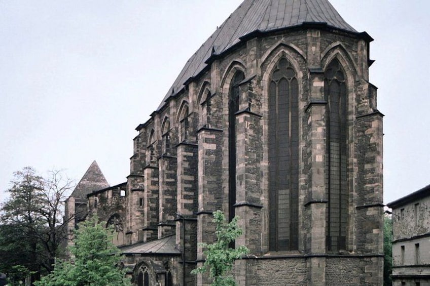 A historic church with a pointed steeple and large arched windows. 2