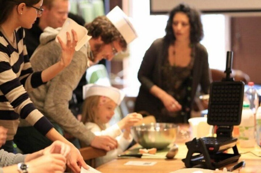 A group of people engaged in a cooking activity with bowls and a microphone. 4