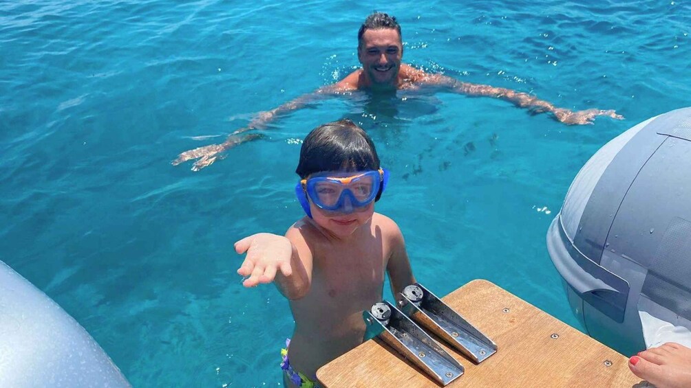 A person in a pool with a diving board and a boat. 5
