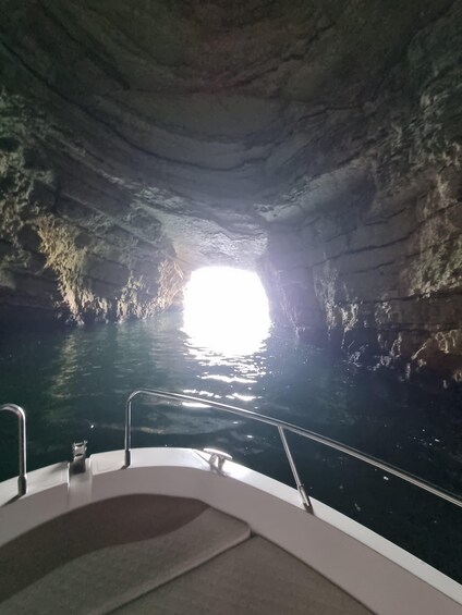 A boat inside a cave with water outside. 3