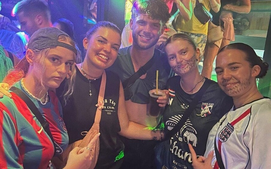 A group of people at a social event, some wearing sports jerseys. 3