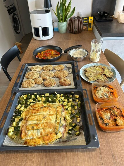 A kitchen with food items on trays, including baked goods and vegetables. 1