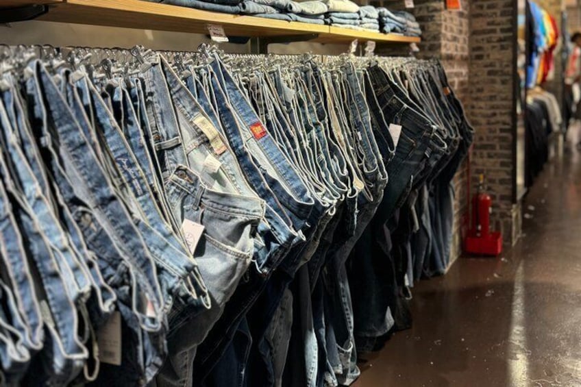 A store aisle with denim jeans on display. 1