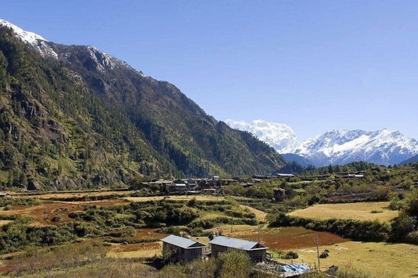 A mountainous landscape with snow-capped peaks, a river, and scattered buildings. 3