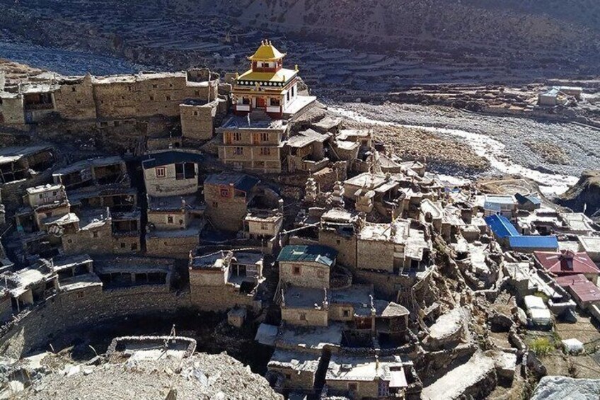 A mountainous village with traditional buildings and a prominent yellow-roofed structure. 4