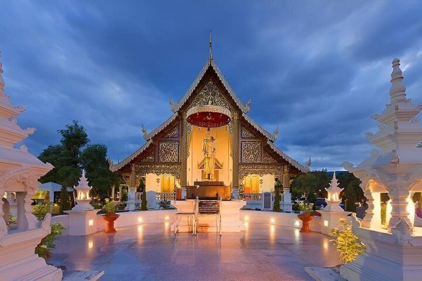 A temple with a central statue, surrounded by smaller structures and a reflective water surface. 2