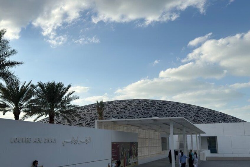 A modern building with a unique geometric facade and palm trees in the foreground. 5