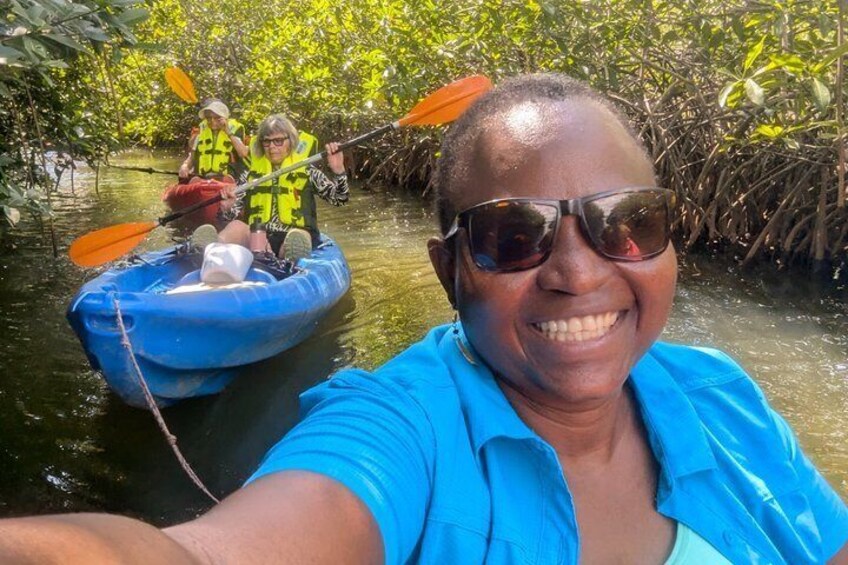 A person taking a selfie with a kayak in a mangrove area. 1