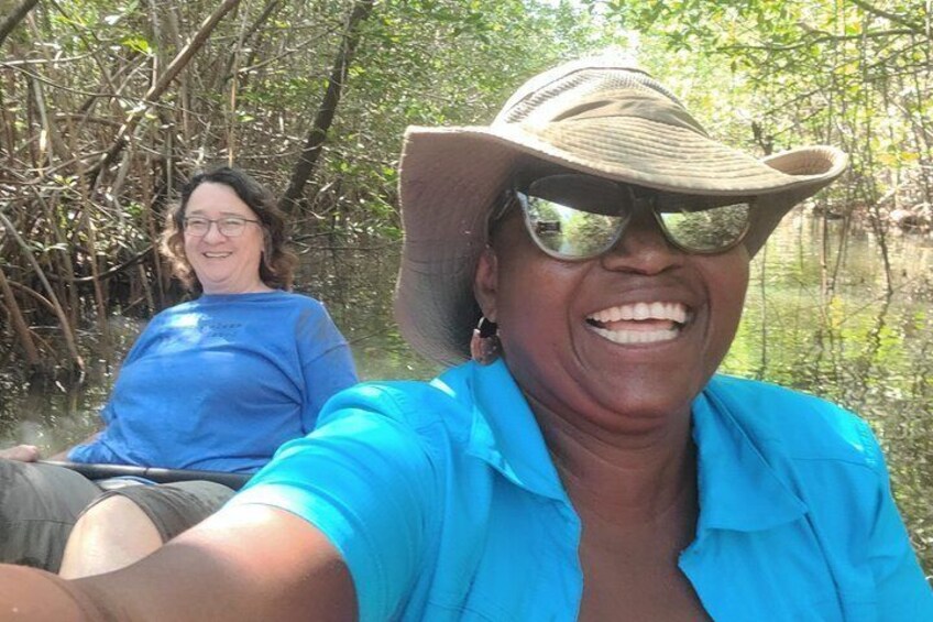 Two people in a forested area, one wearing a blue shirt and the other in a blue shirt and hat. 4