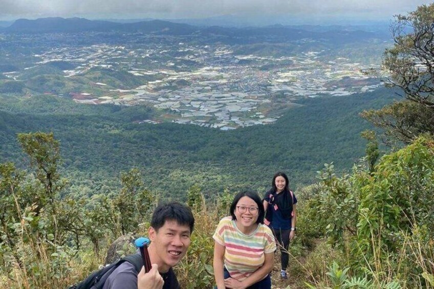 A group of people hiking on a mountain trail with a view of a valley below. 4