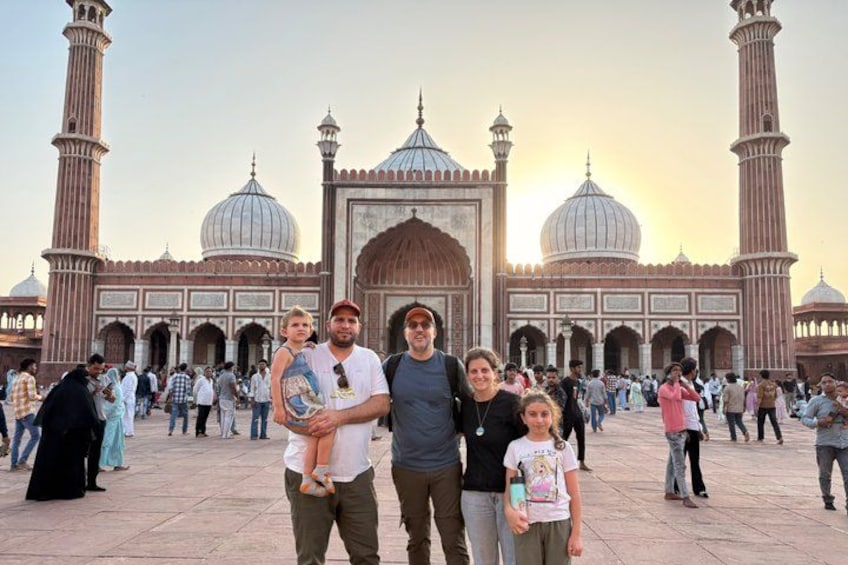 Un groupe de personnes se tient devant une grande mosquée, reconnaissable à ses coupoles et à ses minarets. 1