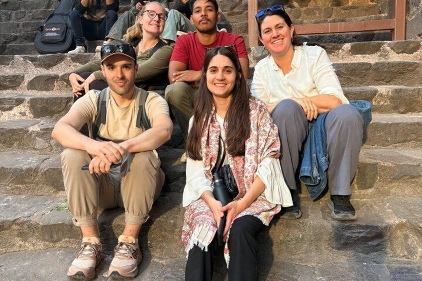 A group of people sitting on stone steps. 5
