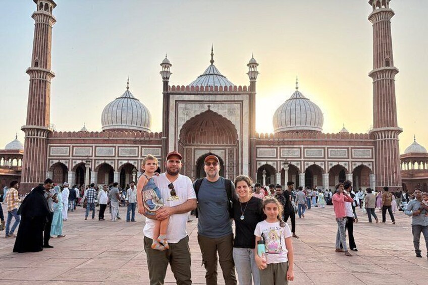 A group of people in front of a large mosque with domes and minarets. 1