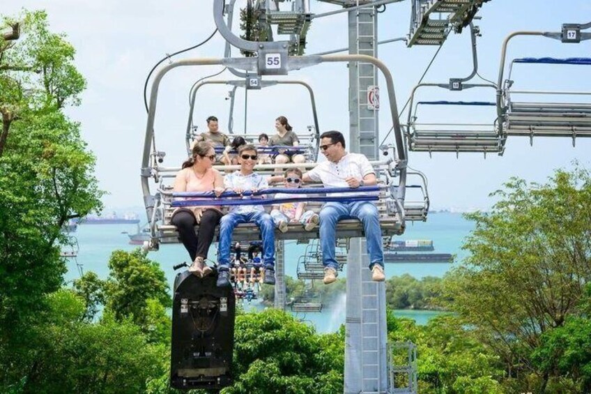 A cable car with passengers, a cable car system, and a body of water in the background. 1