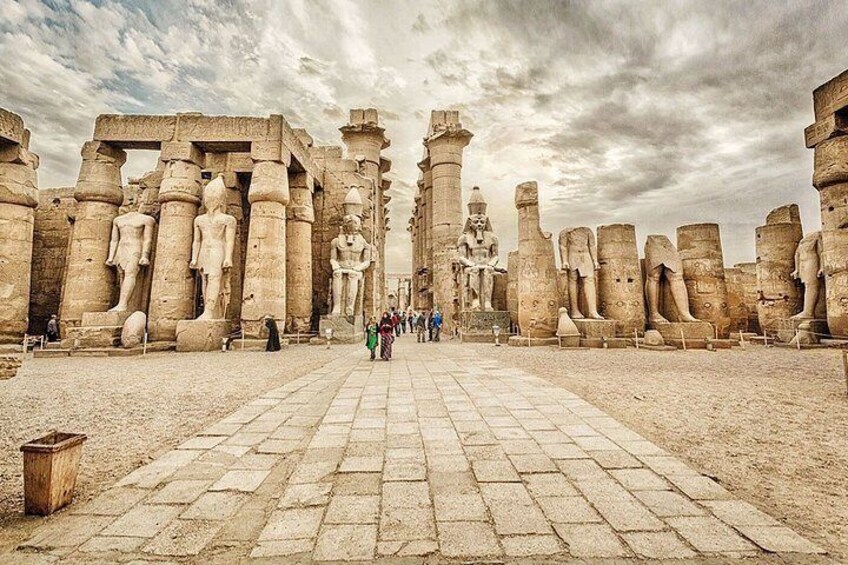 Ancient stone statues and columns in a historical site. 2