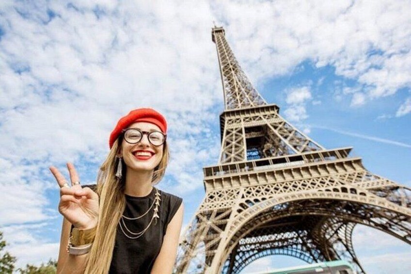 A person with a peace sign in front of the Eiffel Tower. 3