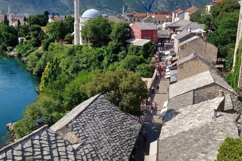 A river, a mosque with a dome, and a cobblestone street. 2