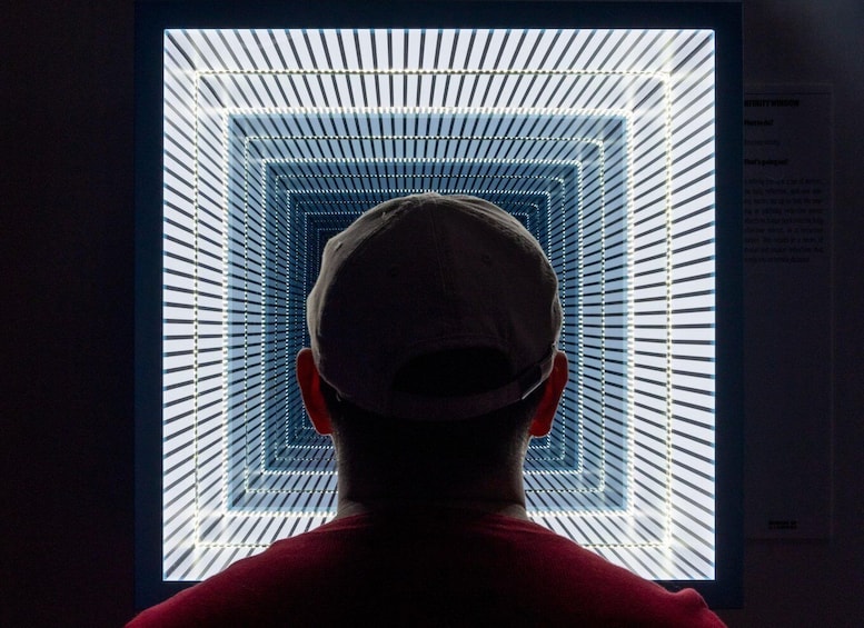 A person facing a lighted geometric pattern. 1