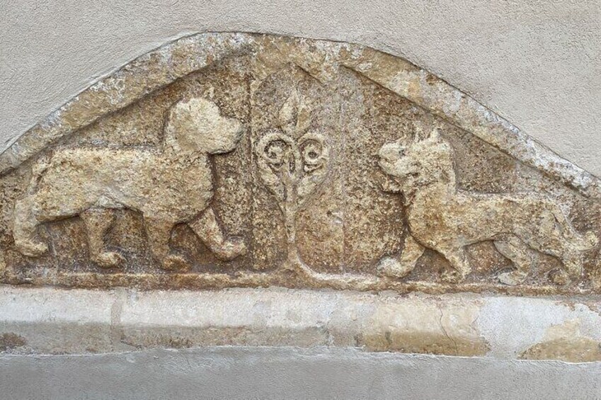 A weathered stone relief of two lions and a tree, possibly part of an ancient wall or monument. 3