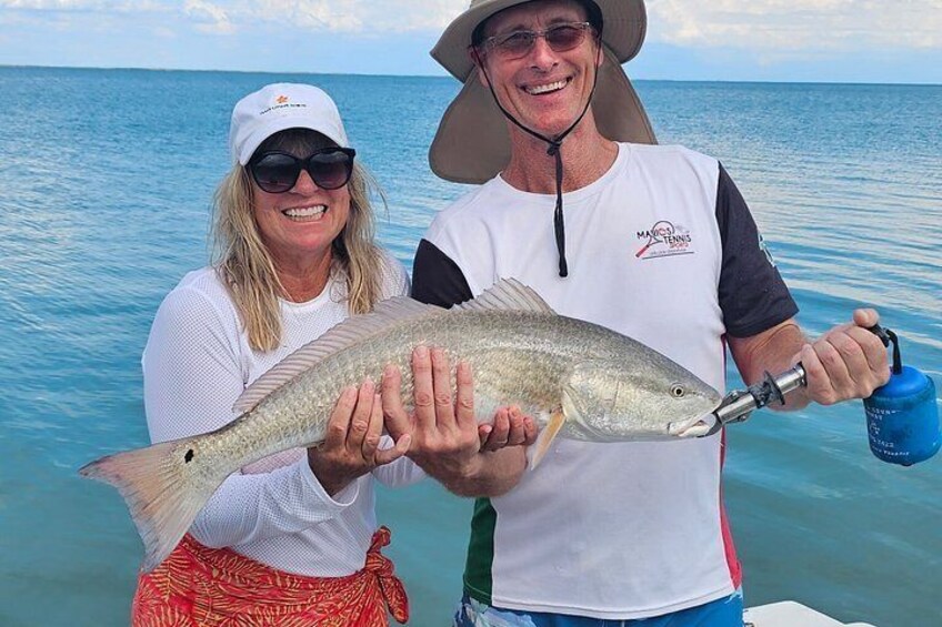 Two people holding a fish on a boat. 3