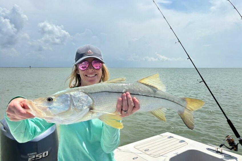 A person holding a fish on a boat with a calm sea and a clear sky in the background. 4