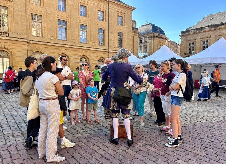 A historical reenactment with a man in period costume engaging with a crowd in an outdoor setting with classical architecture. 5