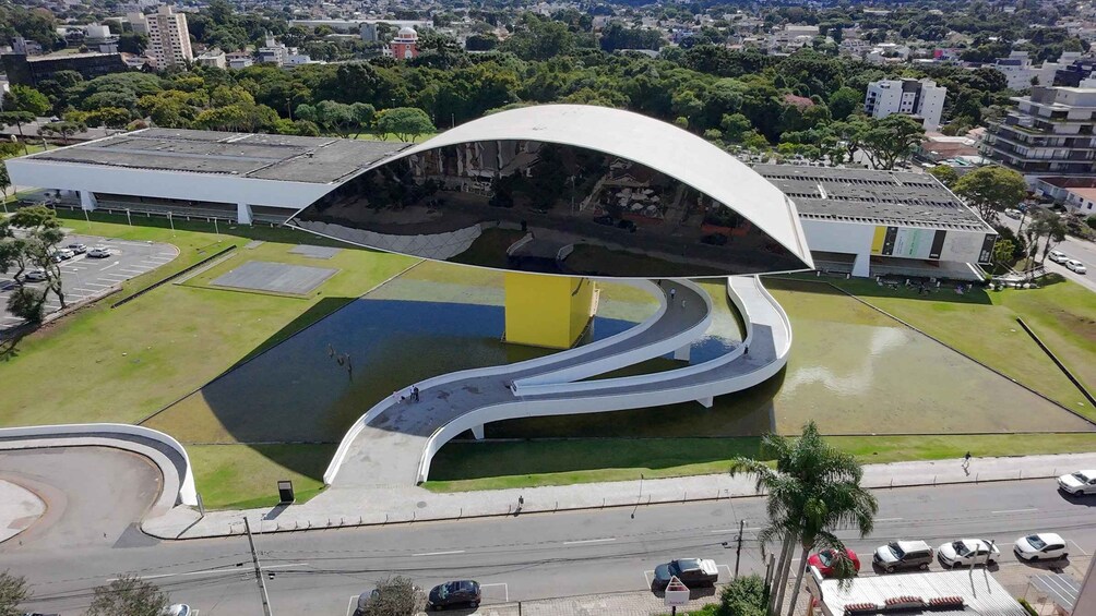 A modern architectural structure with a curved roof and a central water feature. 2