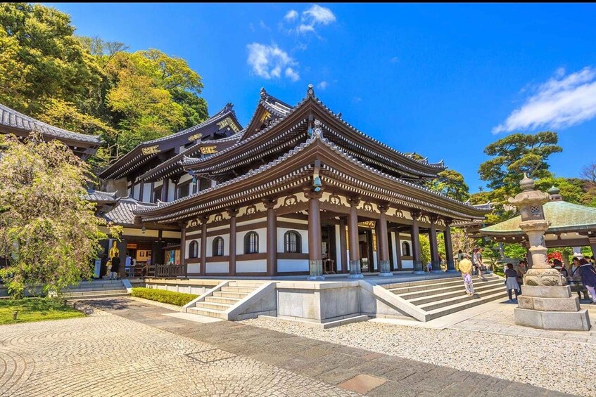 A traditional Japanese temple with a multi-tiered roof, stone steps leading to the entrance, and a stone lantern in the foreground. 2