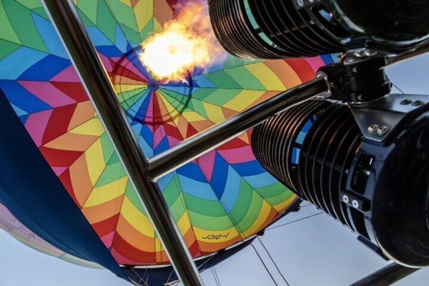 A colorful hot air balloon with flames at the basket. 5