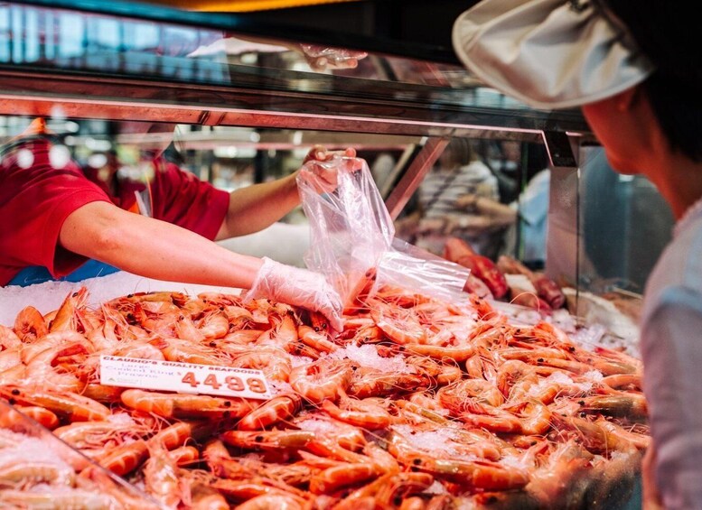 A seafood display with cooked king prawns priced at $4.49 per pound. 3