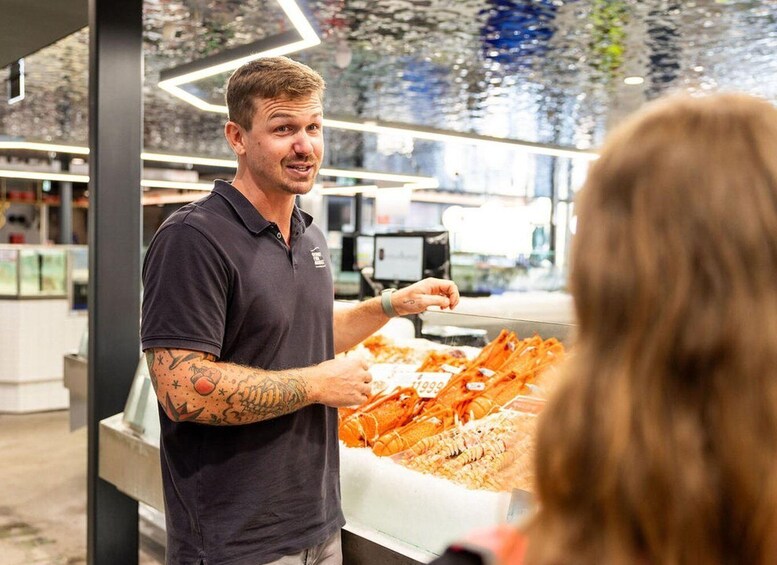 A person serving food at a counter with a glass display case. 4