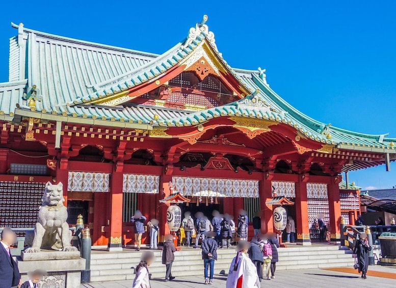 A traditional Japanese temple with ornate architecture and a large statue of a lion-dog. 1